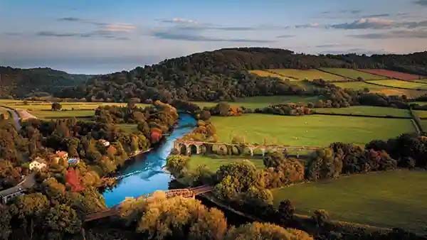 Aerial image of the wye valley, a river meandering through fields, trees and hills