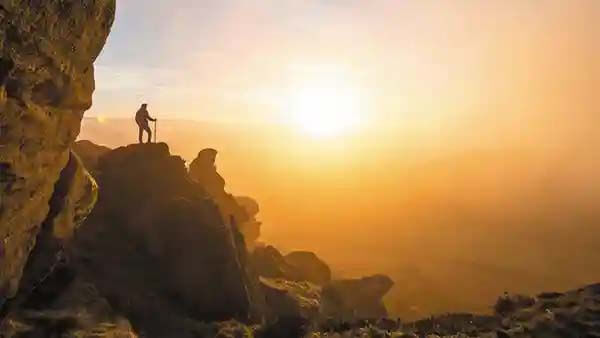 Scenic image of a mountaineer, hiking on a rock overlooking staffordshire